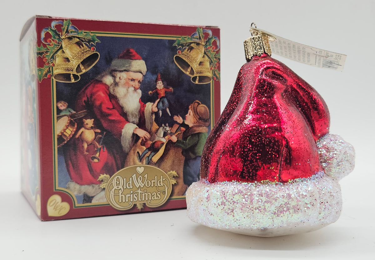 Old World Christmas Santa’s Hat ornament #32102 – ornament alongside photographed packaging