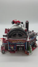 Load and play video in Gallery viewer, Dept 56- North Pole Village &quot;Hot Wheels Custom Car Shop&quot;
